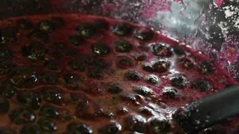Stirring blackcurrant jam in a saucepan close-up with a spoon Video stock 136601435
