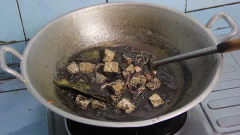 Stirring the boiled black squid in a pan Stock Footage 239000058