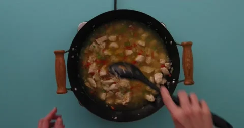 Stirring broth, vegetable mixture, chicken, and rice 1 Video stock 132199382