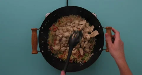 Stirring chicken, rice, and vegetable mixture in a skillet Stock Footage 132199545