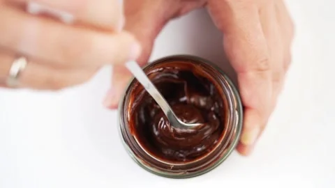 Stirring of chocolate paste with a spoon on white table Vidéo 274050339