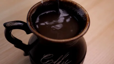 Stirring coffee into the mug closeup Stock Footage 128949522