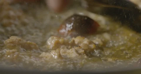 Stirring cooked meat in a pan with cherry tomatoes in slow motion Stock Footage 113047598