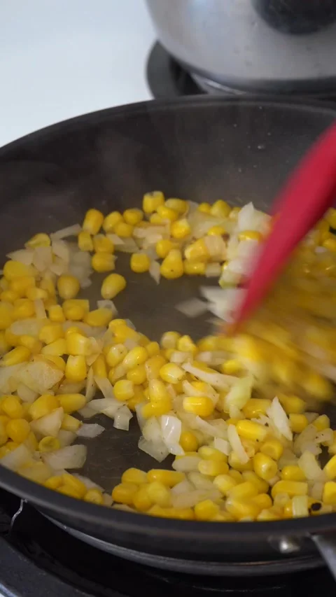 Stirring Corn and Onions in Frying Pan with Red Spatula Stock Footage 288919678