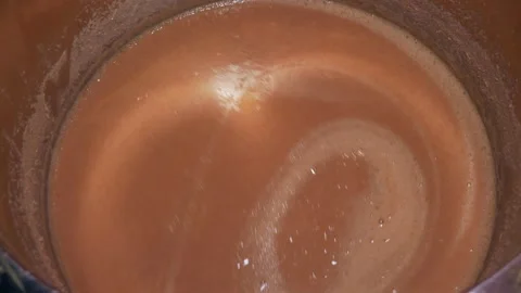 Stirring corn wort while making homemade moonshine Stock Footage 130378718