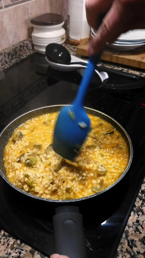 Stirring creamy risotto with chicken broth and artichokes. Stock Footage 345152219