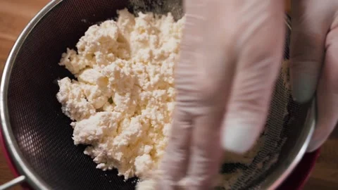 Stirring curd through an iron sieve f Stock Footage 155203093