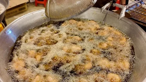 Stirring Deep Fried Donuts in Hot Oil at Thai Street Food Market Stock-Footage 340351155