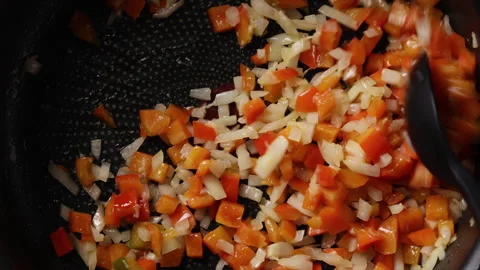 Stirring Diced Onion and Red Bell Pepper in Pan Extreme Close Up Видео 336575885