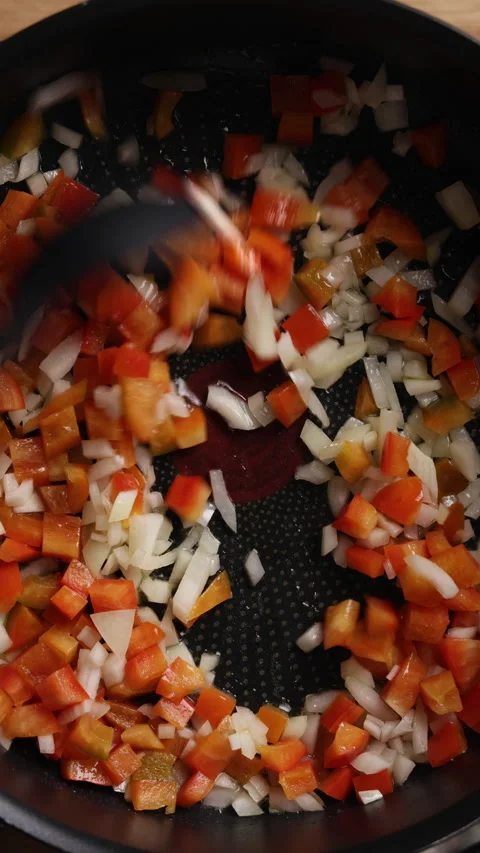 Stirring Diced Onion and Red Bell Pepper with Silicone Spoon in Pan Close Up Vidéo 336577448