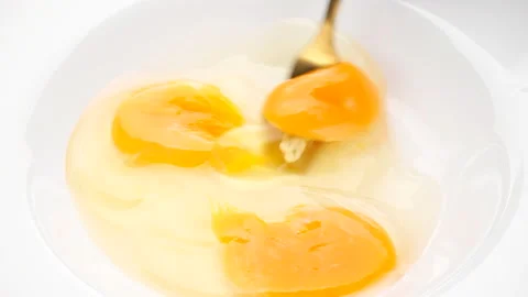Stirring eggs with fork in white plate, close up Stock Footage 221844262