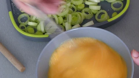 Stirring eggs, preparing omelette with leek, dolly shot Stock Footage 73039675