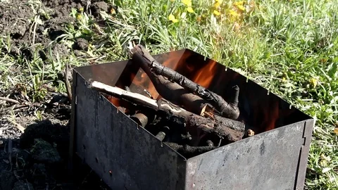 Stirring firewood in the grill to increase the flame Stock Footage 89433966