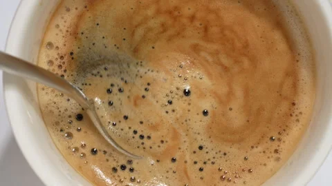 Stirring fresh espresso coffee with spoon top view 스톡 동영상 345815615
