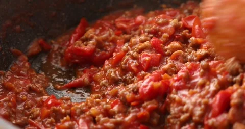 Stirring the fried minced meat and tomato sauce in a frying pan. Stock Footage 249663668