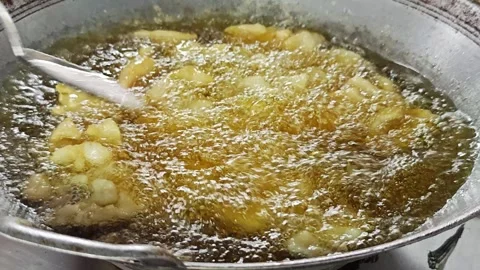 Stirring golden crispy fried fish pieces in boiling oil. Stock Footage 342696529