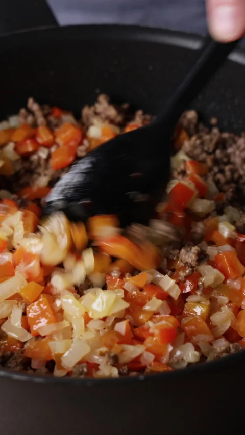 Stirring Ground Beef with Diced Vegetables in Pan Front View Видео 336576449