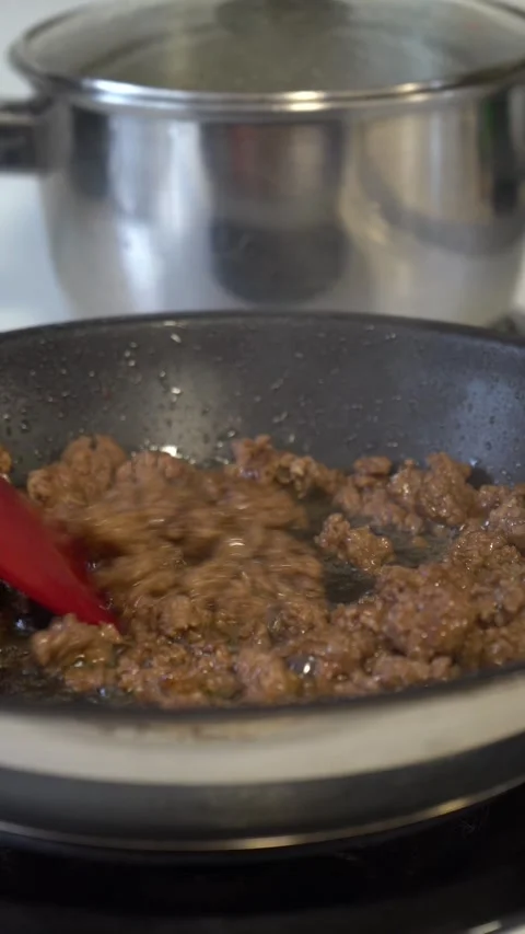 Stirring Ground Meat with Red Spatula in Non-Stick Pan on Stove Stock Footage 288919668