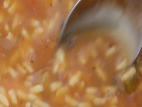Stirring gumbo with a spoon while heating Stock Footage 75650119