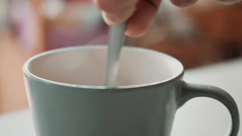 Stirring hot coffee cup with spoon. Hot coffee with steam in slow motion Stock-Footage 147938573