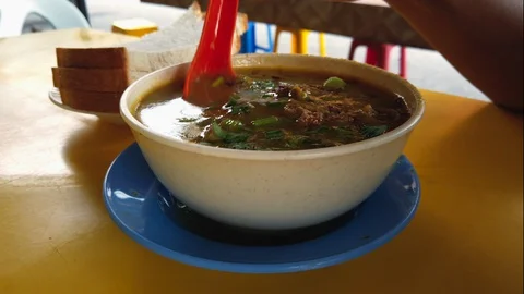 Stirring hot mutton soup or kambing sup a Mamak Cuisine Stock Footage 128314023