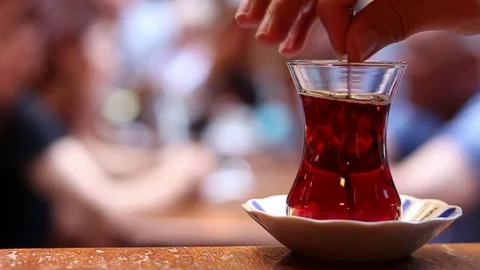 Stirring hot tea on the old and old Turkish coffee table in Istanbul Stock Footage 116120697