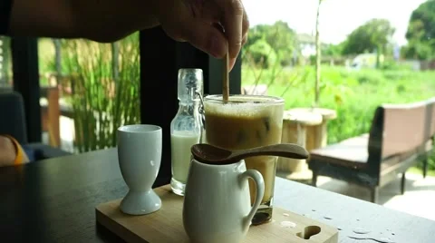 Stirring ice coffee with nature background Stock Footage 47494615