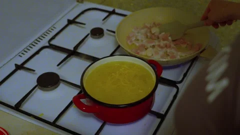 Stirring Ingredients in Frying Pan While Pasta Boils on Stove Stock Footage 341767078
