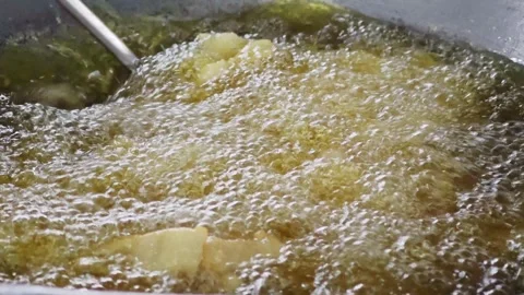 Stirring large batch of crispy fried fish in boiling oil. Stock Footage 342688049