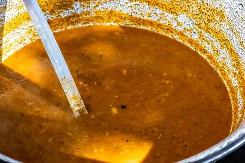 Stirring a Large Pot of Simmering Soup Stock Photos
