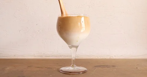 Stirring layered coffee with wooden spoon to mix up Stock Footage 106907486