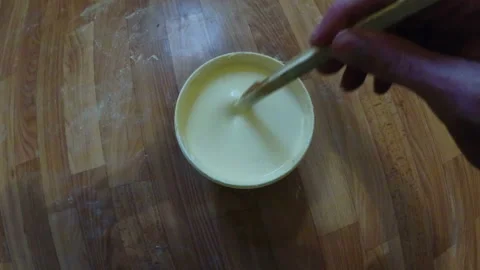 Stirring light yellow paint Stock Footage 94864489