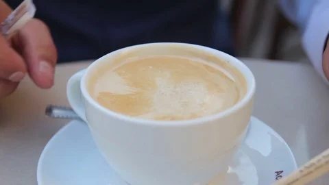 Stirring the milk in a cup of coffee Stock Footage 72670856