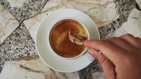 Stirring Milk in Cup of Coffee with Tea Spoon. Top View Stock Footage 101435673