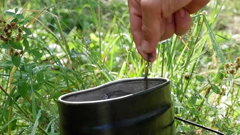Stirring a newly brewed tea in a tin can Stock Footage 211639716