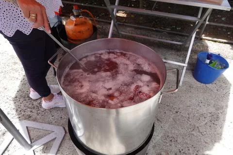Stirring Octopus Boiling in Large Pot Over Outdoor Stove Stock Photos