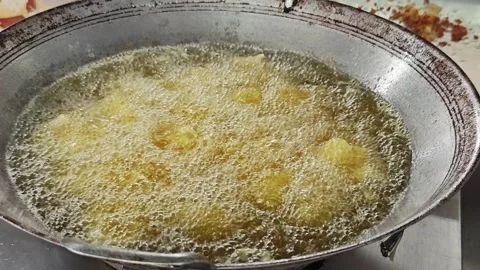 Stirring pieces of fish in a wok of boiling frying oil. Stock Footage 342781437