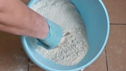 Stirring the plaster mixture in a regular blue household plastic bucket by hand Stock Footage 166444523