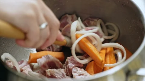 Stirring raw meat and vegetables with a spatula Stock Footage 105787553