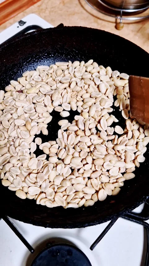 Stirring Raw Peanuts in Skillet with Wooden Spatula Stock Footage 321462553