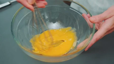 Stirring the raw yolk with a kitchen whisk Видео 252184731