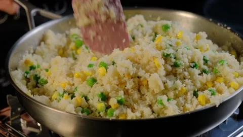 Stirring Rice with Peas and Corn in Kitchen Skillet Video stock 341424074