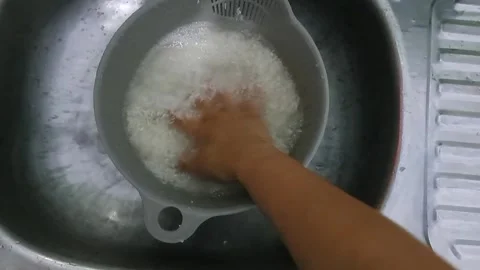 Stirring Rice While Washing in Sink Stock Footage 331415045