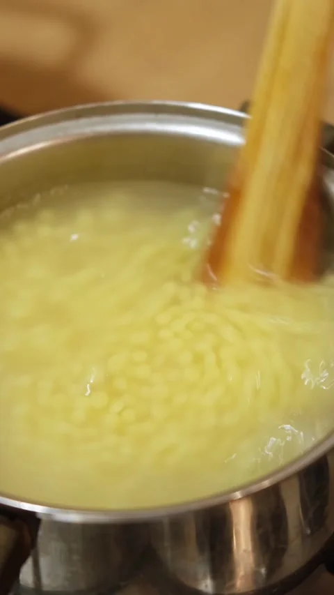 Stirring small round pasta or couscous with a wooden spoon Vidéo 344266863