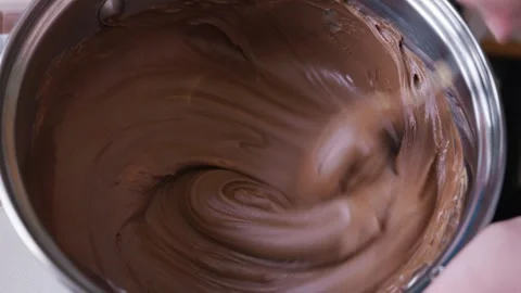 Stirring Smooth Melted Dark Chocolate in a Stainless Steel Pot Video stock 333822085