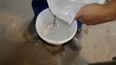 Stirring solution for room repair, dry white solution is mixed with a perforator Stock Footage 88689602