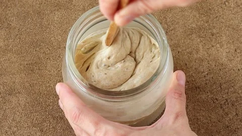 Stirring the sourdough starter Stockbeeldmateriaal 234439678