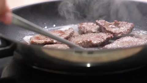 Stirring Steaks in a Frying Pan. Stock Footage 256223933
