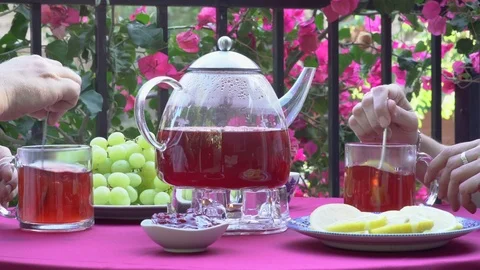 Stirring sugar in cups at table with teapot fruit tea Stock Footage 78477504