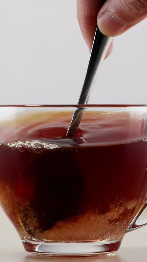Stirring Sugar into Hot Black Tea in Clear Glass Mug Stock Footage 346595179